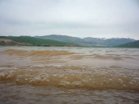 Charvak lake in Uzbekistan with dirty clay water close-up