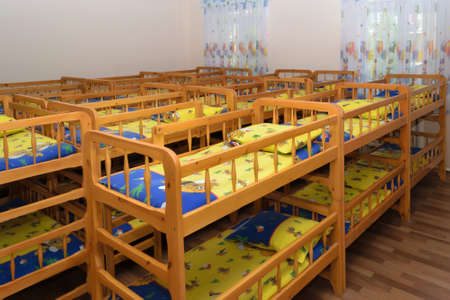 Bunk wooden children's beds neatly made bedrooms in kindergartenの写真素材