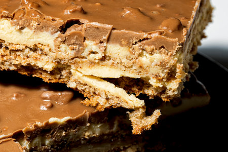 Slice of Swedish almond and chocolate cake with filling and nuts