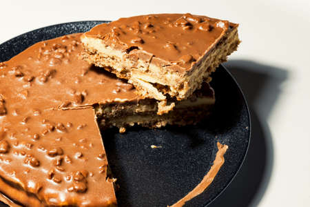 Swedish almond and chocolate cake with a slice cut off, with filling and nutsの写真素材