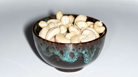Lots of raw cashews in a ceramic bowlの写真素材