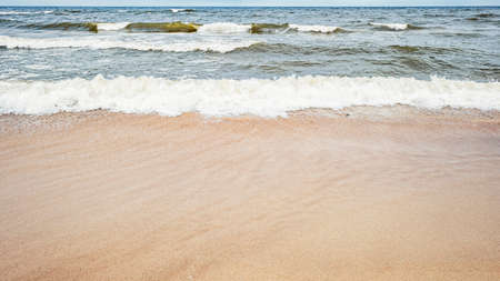 Sea waves on the beach and overcast sky