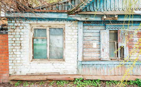 House in traditional Russian style, the second half of the house made of brick in a dilapidated conditionの写真素材
