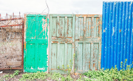 Fence in the Russian countryside from different kinds of materials