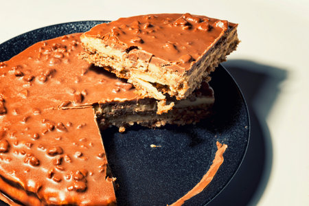 Swedish almond and chocolate cake with a slice cut off, with filling and nutsの写真素材