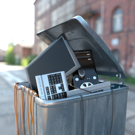computers in a trash bin on a street