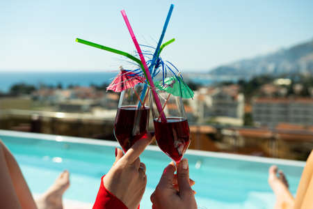 Two tropical cocktails near swimming pool and beachの写真素材