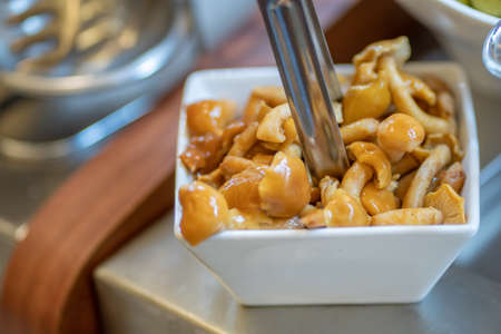 Closeup of a white bowl with some cooked mixed mushrooms.の写真素材