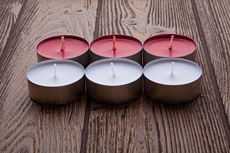Red and white candles on the wooden table