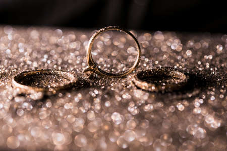 gold wedding rings on an abstract background with copy spaceの写真素材