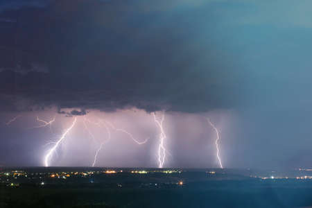lightning storm over city. Lightning strike over dark blue sky in night city.の写真素材