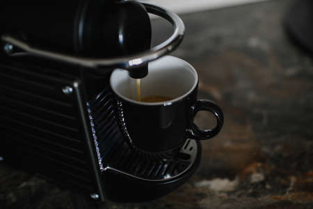 Black coffee machine pouring espresso into cup.の写真素材