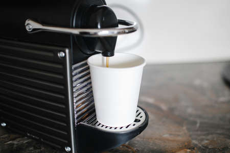 Black coffee machine pouring espresso into cup.の写真素材