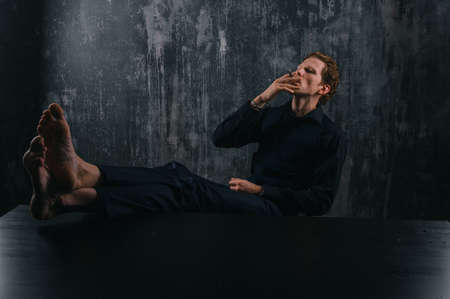 Mystery man with cigar and smoke isolated on black background.man put his legs on the table and...