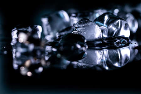 pile of different ice cubes on reflection table on black backgroundの写真素材