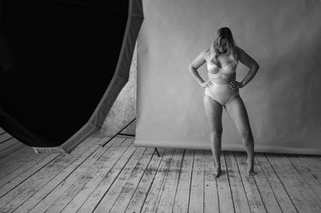 Young beautiful fat girl model posing for a photo shoot in a studio. body positiveの写真素材