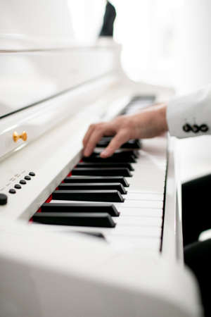 Close up of man hands piano playing. Male pianist hands on grand piano keyboardの写真素材