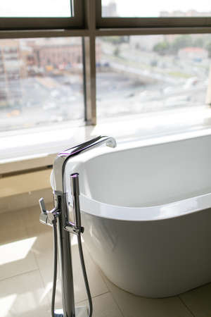 Pure white bathroom interior with separate bathtub. Bathroom with big windowsの写真素材