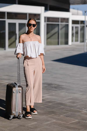travel concept. young girl with a suitcase at the train stationの写真素材