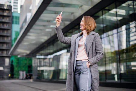 Beautiful young woman is making selfie photo with smartphone