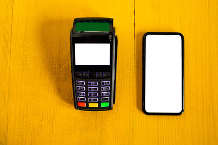 payment terminal and smartphone top view. Mockup. Yellow background