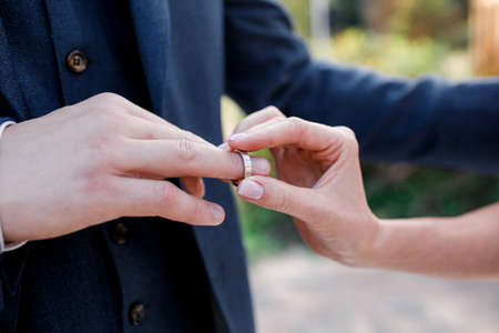 marriage hands with rings. birde wears the ring on the finger of the groomの写真素材