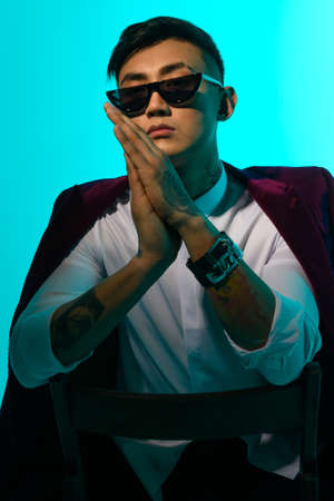 portrait of a fashionable asian man with glasses and a jacket