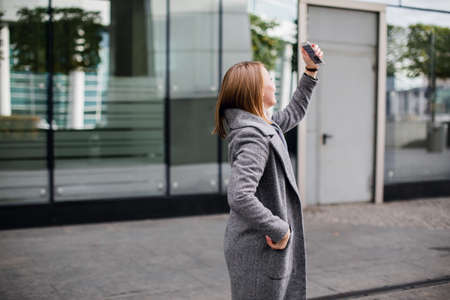 Beautiful young woman is making selfie photo with smartphoneの写真素材