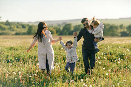 Happy young family spending time together outside in green natureの写真素材