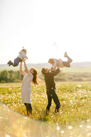 Happy young family spending time together outside in green natureの写真素材