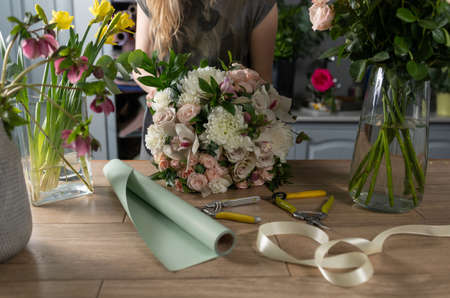Floral shop concept . Florist woman creates flower bouquet. Beautiful bouquet of mixed flowers. Handsome fresh bunch. Flowers deliveryの写真素材