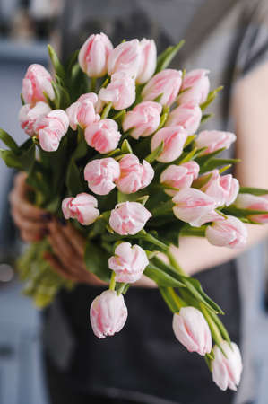 girl holding a large bouquet of tulips in her handsの写真素材