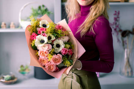 Large beautiful bouquet of mixed flowers in woman hand. Floral shop concept . Handsome fresh bouquet. Flowers deliveryの写真素材