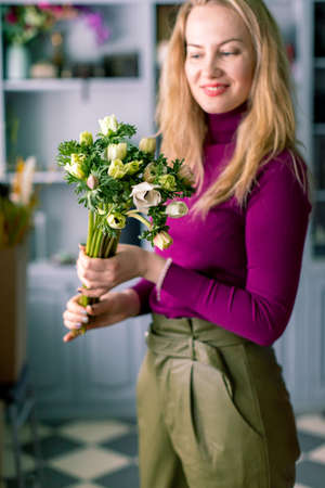 Female florist holding bouquet of red roses. On Valentines day holidayの写真素材