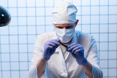 Male Doctor with files on hospital holding clipboard and writing a prescription. Healthcare and...