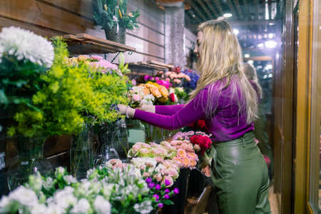 young woman florist standing and working in flower shop.の写真素材