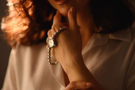  Stylish watch on woman hand. Golden analog wrist watch. の写真素材