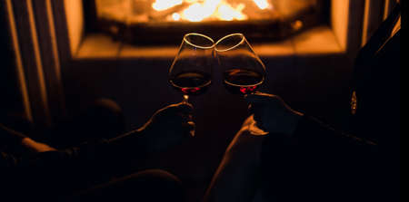 girl and man at the fireplace drink wineの写真素材