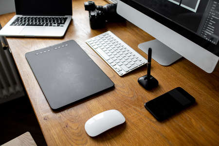Creative professional designer's desk from above. Designer workspace top view with essential elements on wooden tableの写真素材