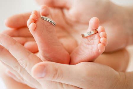 Baby feet in mother hands. Mom and her Child. Happy Family concept. Beautiful conceptual image of Maternityの写真素材