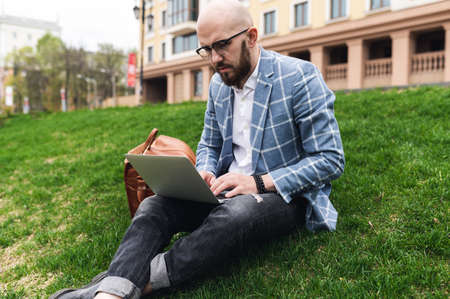 Young man using laptop outdoor. Freelance, student lifestyle, education, technology and online shopping conceptの写真素材