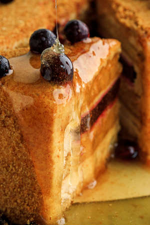 honey cake decorated with black currant and with honeyの写真素材