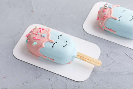 ice cream on a stick covered with blue and pink chocolate.の写真素材