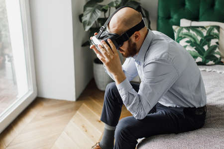 Man experiencing VR headset while lying on sofa