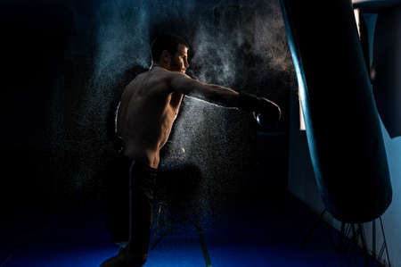 Sportsman boxer fighting on black background with smoke. Boxing sport concept. Shadow fightの写真素材