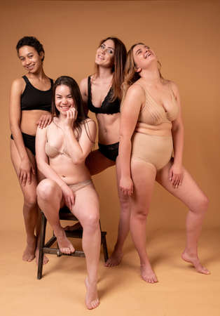 Beautiful fat girls in black lingerie on pink background. Body positive concept. Group of women with different body and ethnicityの写真素材