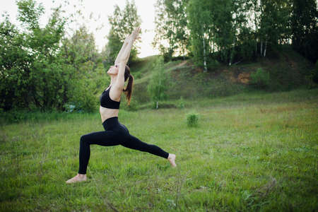a sporty girl does yoga in the Park. Outdoor sports activitiesの写真素材