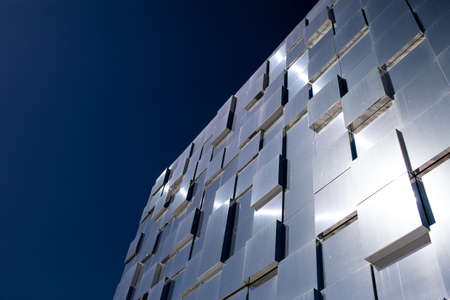 a modern glass building that reflects the sky