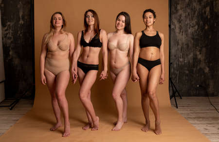 Beautiful overweight woman in beige swimsuit on pink backgroundの写真素材