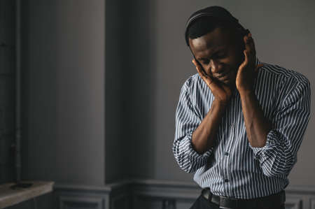 an African American with headphones listening to music and enjoying and slowly dancing